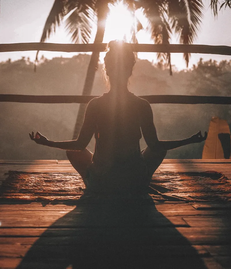 Morning yoga session on an outdoor cliff deck overlooking the ocean at sunrise